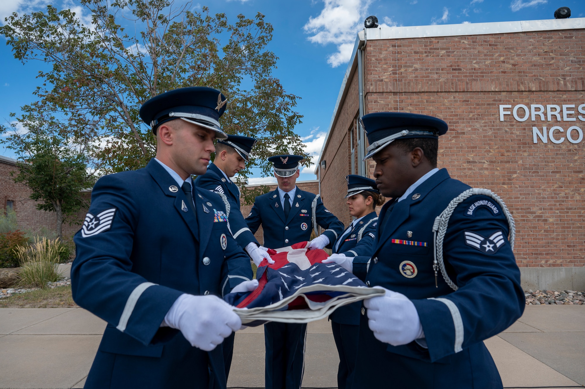 Members of the High Frontier Honor Guard fold the U.S. Flag during the Space Base Delta 1 POW/MIA Retreat Ceremony at Peterson Space Force Base, Colorado, Sept. 16, 2022. Honor Guard members fold the flag in a triangle pattern 13 times to represent the original 13 U.S. colonies, displaying only blue with white stars when completed. (U.S. Space Force photo by Airman 1st Class Aaron Edwards.)