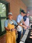 Three people grill.