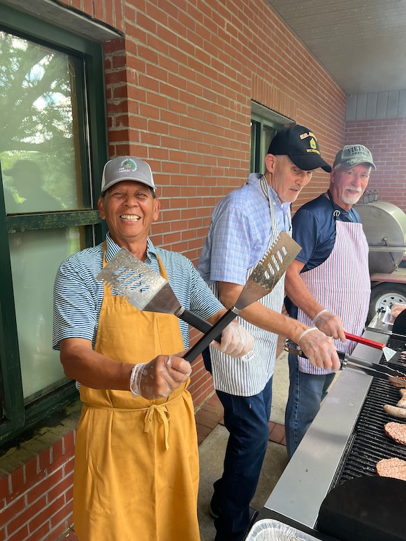 Three people grill.