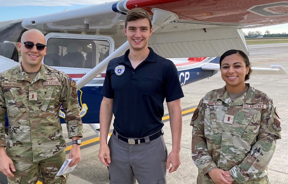 Flight students pose with their instructor in front of a Civil Air Patrol airplane.