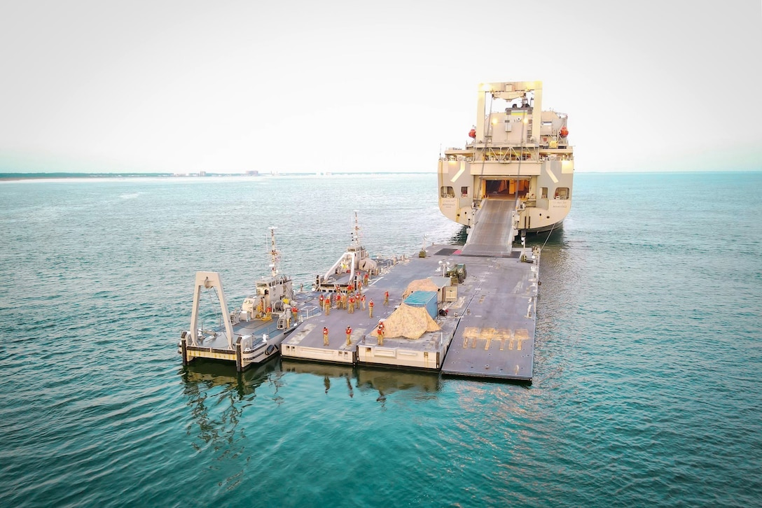 A floating pier-type structure connects to a ship's ramp in water.