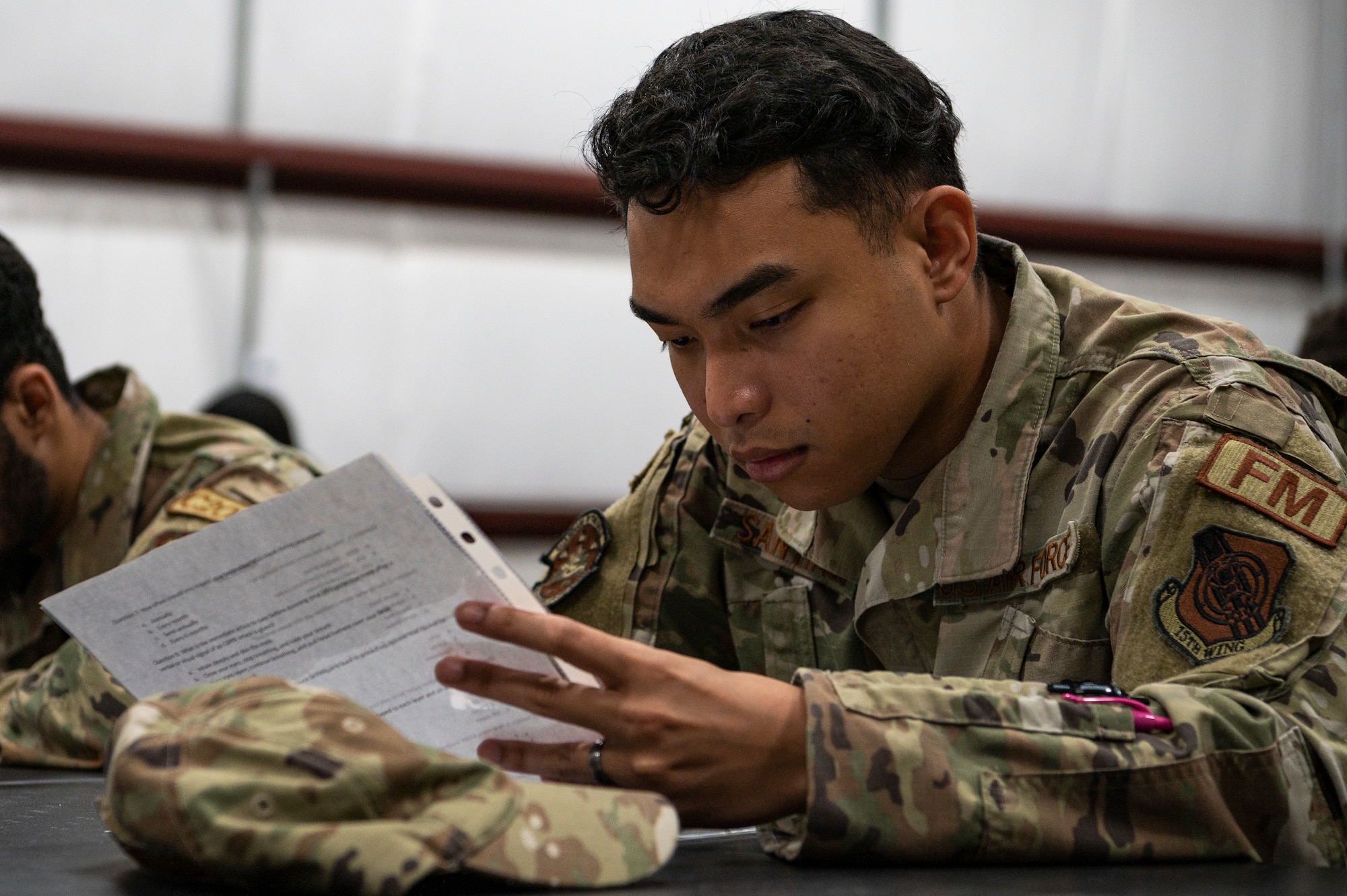 Senior Airman Clark Kevin Santiago, 15th Wing financial manager, takes a test on chemical, biological, radiological and nuclear defense, during a CBRN exercise Sept. 14, 2022, at Joint Base Pearl Harbor-Hickam, Hawaii. The test covered various CBRN procedures, such as nerve agent identification and how to wear protective equipment. (U.S. Air Force photo by Staff Sgt. Jacob M. Thompson)