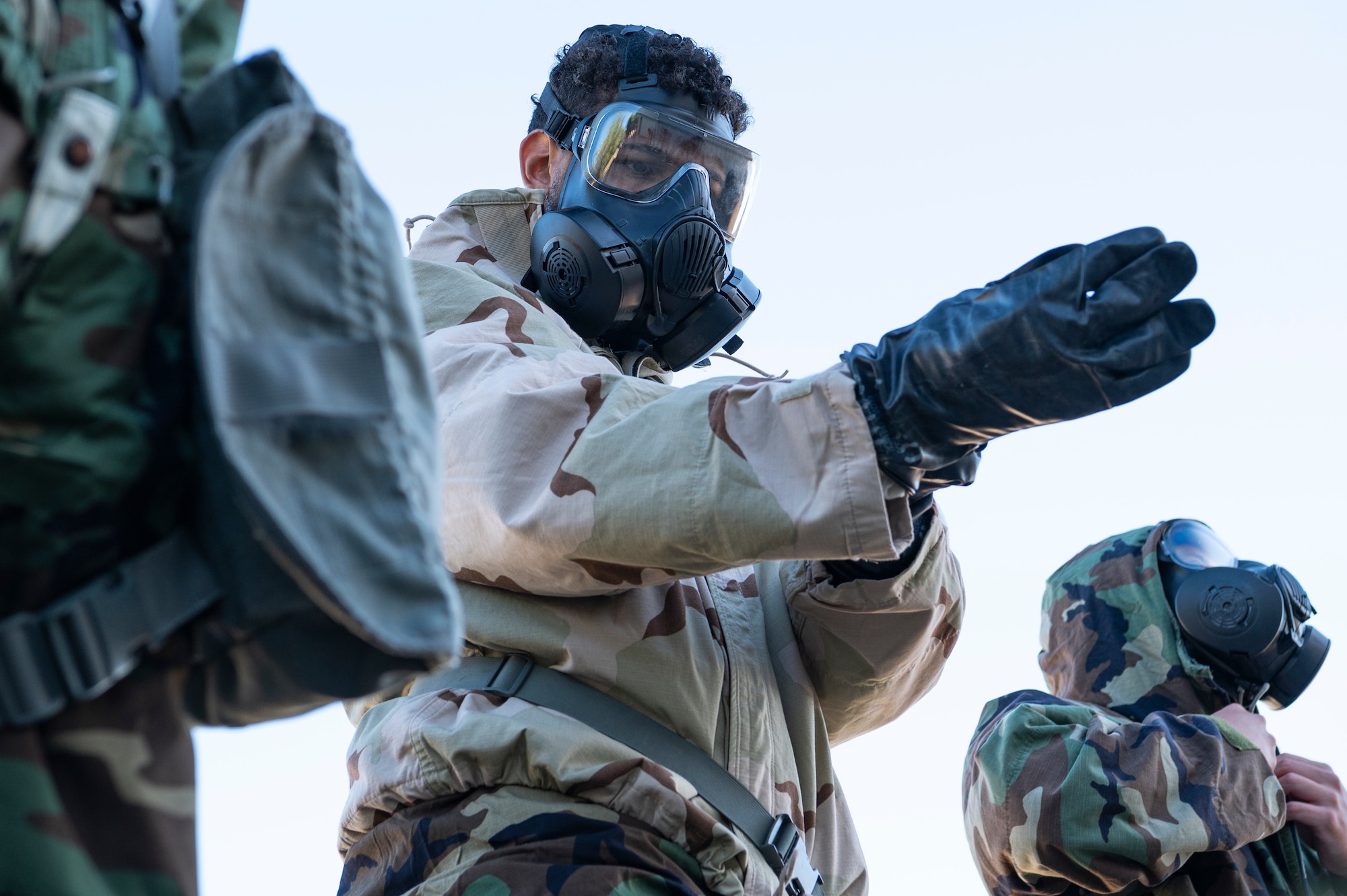 An Airman puts on a component of Mission Oriented Protective Posture gear, during a chemical, biological, radiological and nuclear defense exercise Sept. 14, 2022, at Joint Base Pearl Harbor-Hickam, Hawaii. MOPP gear is designed to keep CBRN agents from harming the wearer. CBRN defenses are protective measures taken in situations in which chemical, biological, radiological or nuclear warfare hazards may be present. (U.S. Air Force photo by Staff Sgt. Jacob M. Thompson)