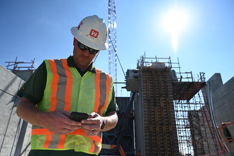 Civil engineer in construction safety equipment reviews construction work.