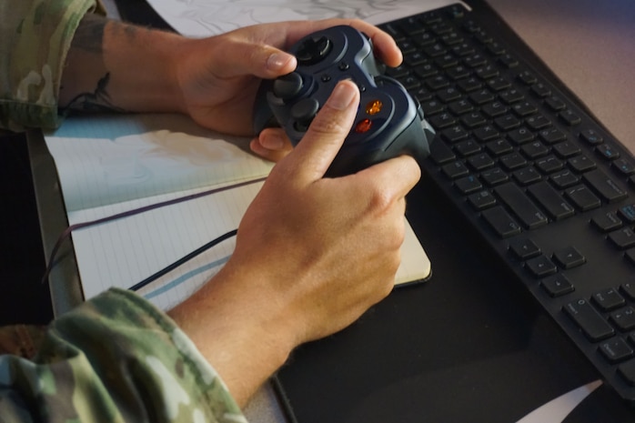 photo of US Military member’s hand-held a video game hand-held controller