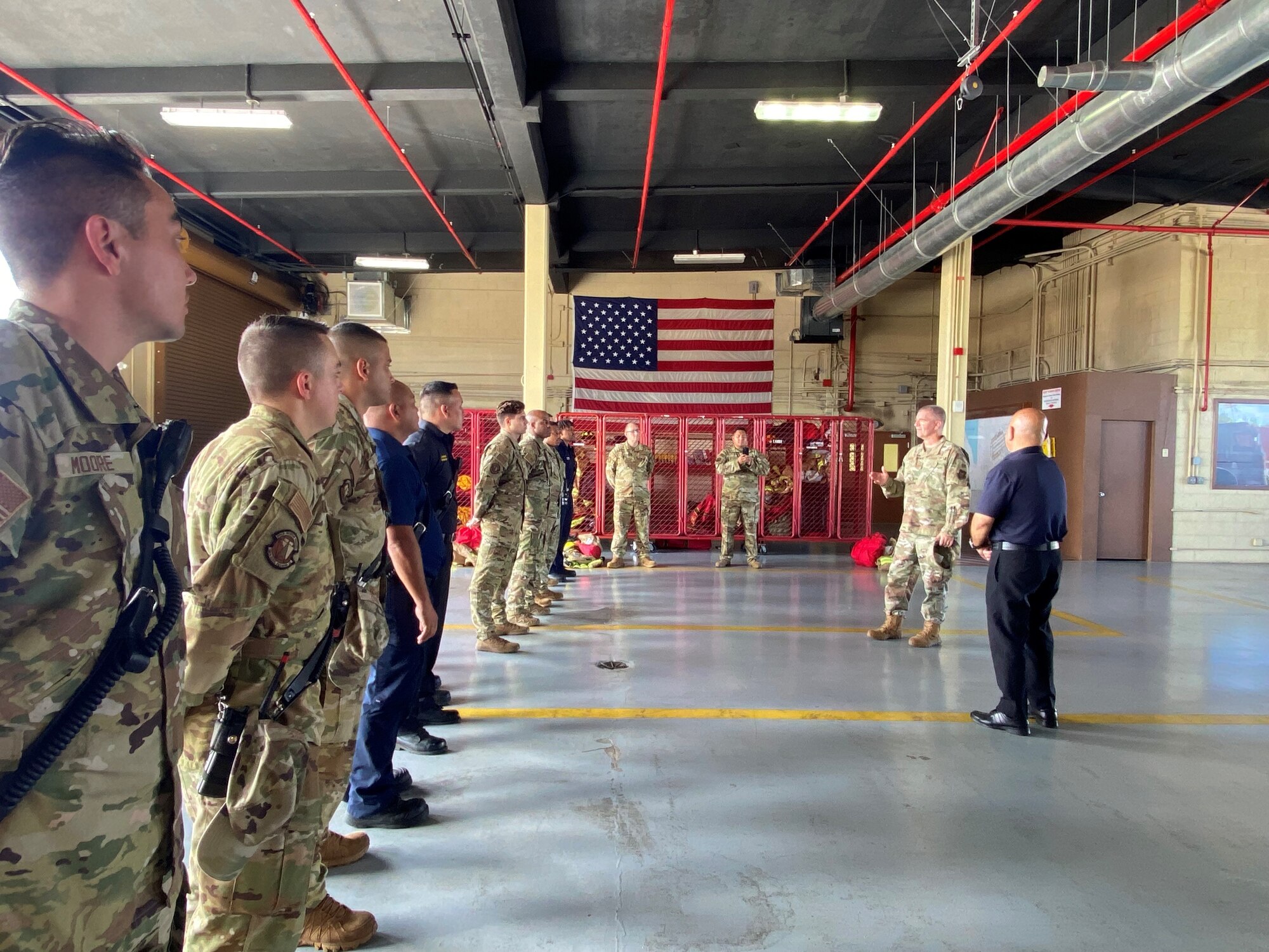 Col. Joseph Orcutt and Fire Chief Stanley Torres stand in front of and address 624 RSG members and Andersen Fire personnel in fire truck garage.