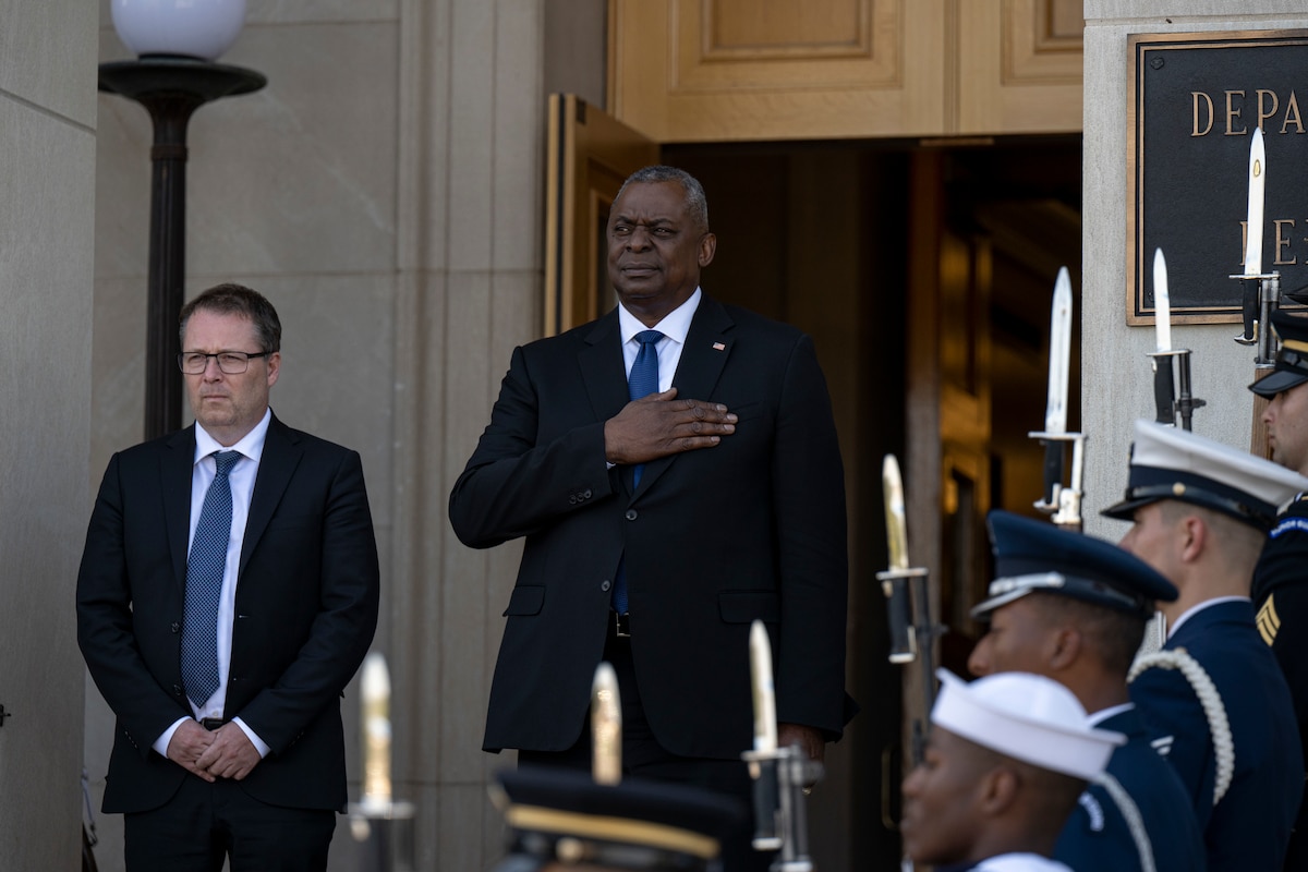 Two men stand on the steps of the Pentagon.
