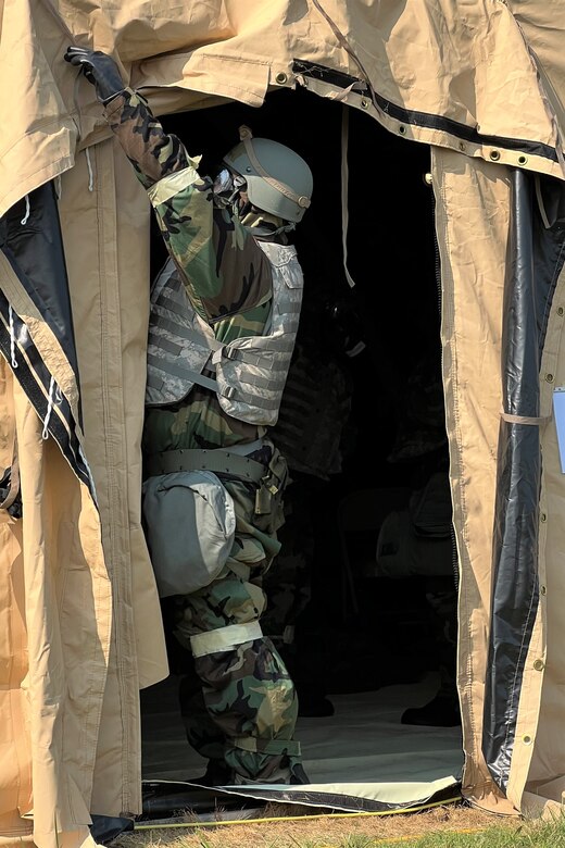 An Airman ties back a doorway on a tent during a readiness exercise on Friday, September 16, 2022 at Biddle Air National Guard Base. The Airman was responding to a simulated chemical attack while trying to maintain operations in a deployed scenario. The readiness exercise took place from September 15 to September 17 and validated the Wing’s pre-deployment and deployment readiness capabilities.