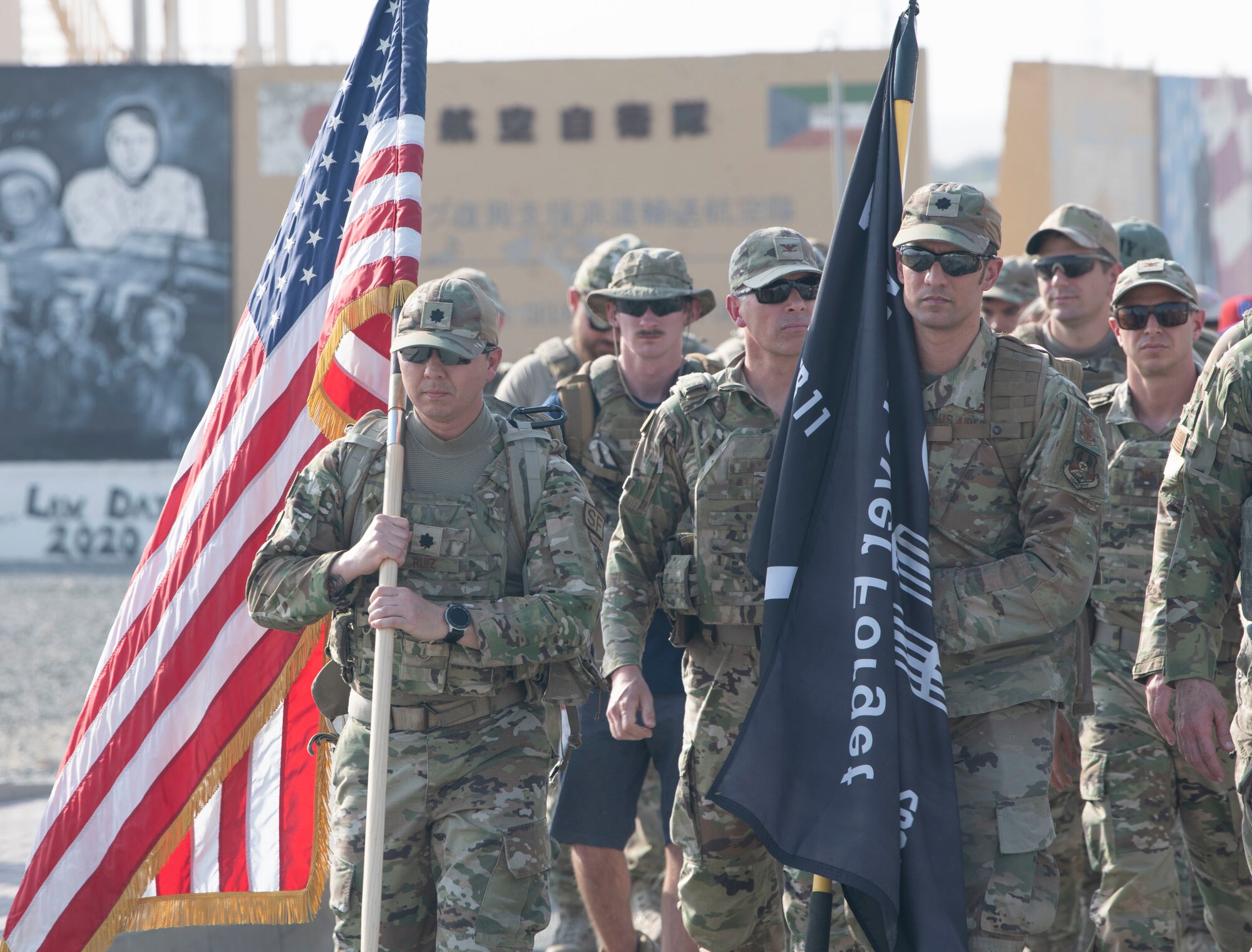 U.S. Airmen along with coalition partners from Ali Al Salem Air Base, Kuwait, step off for the first lap of a 24-hour ruck march led by commanders of each first-responder squadron on base, September 11, 2022. The ruck started at 3:46 p.m. Arabian Standard Time--the exact time the first plane hit the World Trade Center North Tower when converted from Eastern Daylight Time that day, and continued for 24 hours. The flags were carried the entirety of the ruck. (U.S. Air Force photo by Staff Sgt. Ashley N. Mikaio)