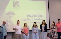 A group stands in front of the projector screen.