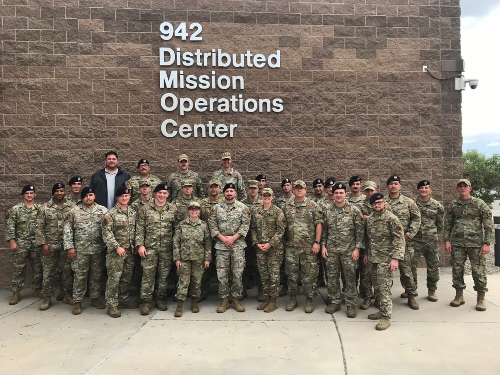 photo of a large group of US military personnel standing in front of a building