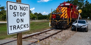 Train and crashed car next to railroad crossing