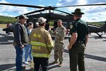 New Hampshire Adjutant Gen. David Mikolaities meets with town officials and residents alongside a NHARNG Black Hawk helicopter during a Berlin Regional Airport open house Sept. 16, 2022, in Milan, New Hampshire.