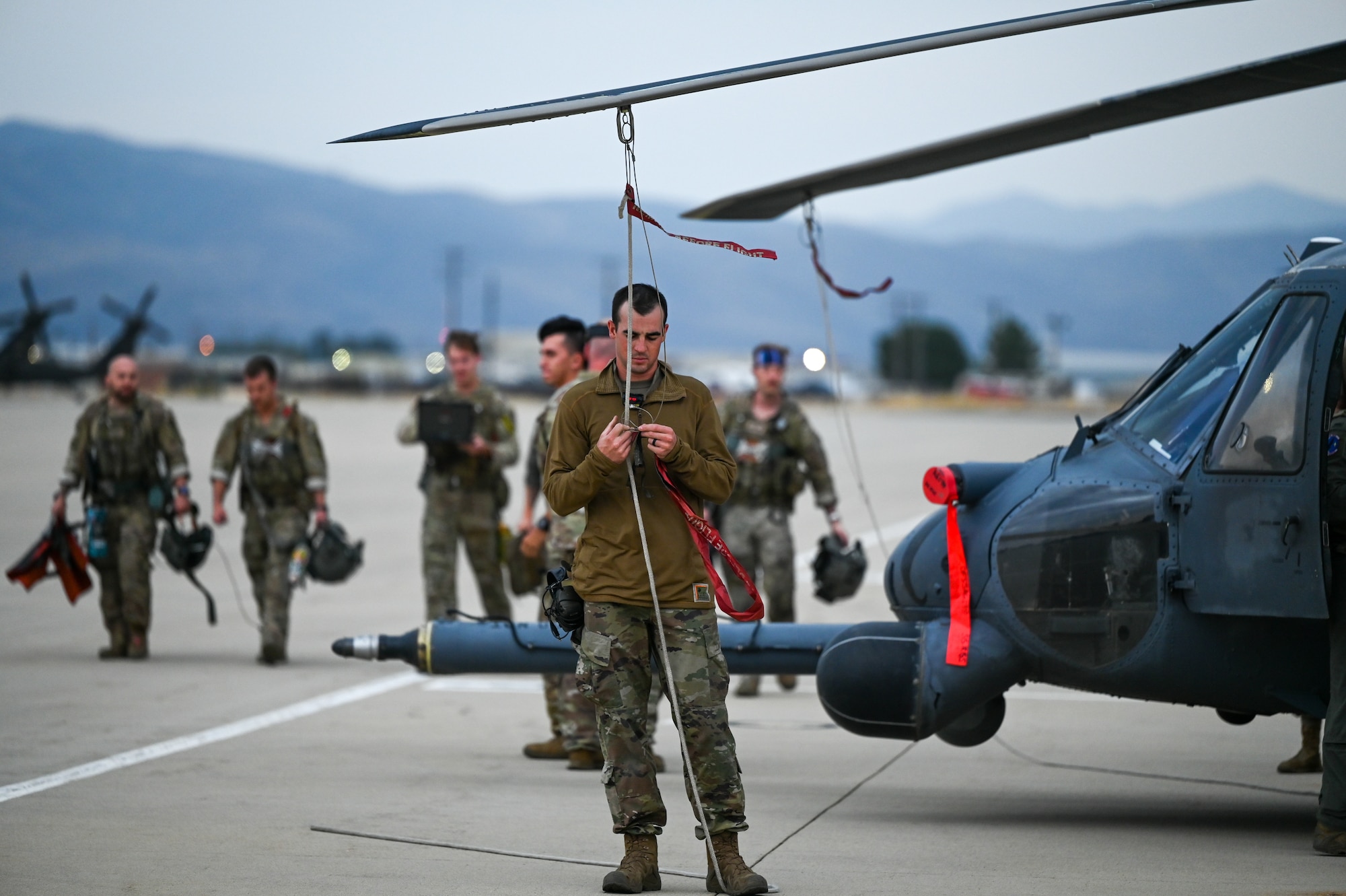 A photo of an Airman tying down an HH-60G Pavehawk's blades.