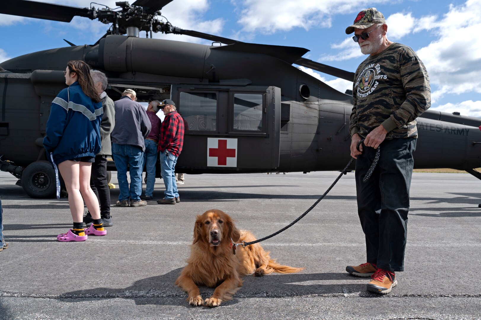 Lionel Turgeon of Milan and his rescued pet, Maverick, take a break alongside a NHARNG Black Hawk helicopter during a Berlin Regional Airport open house Sept. 16, 2022, in Milan, New Hampshire.