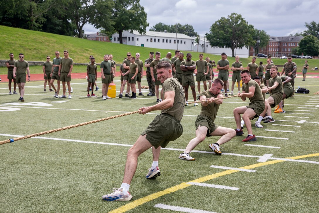 U.S. Marines with Security Battalion participate in a tug-of-war competition during a field meet at Butler Stadium on Marine Corps Base Quantico, Virginia, June 24, 2022. Field meets test the Marines physical fitness through competitive team events while boosting morale and camaraderie. The meet included a water carry relay race, tug-of-war competition, and fast paced musical chairs. Team Wee-Woo from the Provost Marshal Office finished in first place, followed by Team COMMSTRAT from Communication Strategy and Operations in second place. (U.S. Marine Corps photo by Ashley L. Boster)