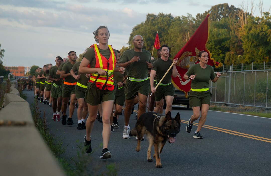 U.S. Marine Corps Cpl. Cierra Smith, a military working dog handler, with the Provost Marshal Office, assigned to Security Battalion, participates in a unit formation run with her military working dog, Busz at Marine Corps Base Quantico, Virginia, Aug. 24, 2022. The motivational run built camaraderie and unit cohesion, and promoted physical fitness among Marine. (U.S. Marine Corps photo by Cpl. Andrew Herwig)