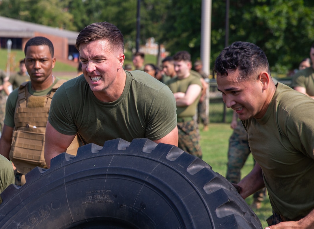 U.S. Marine Corps Warrant Officer Seth Smith and Cpl. Jesse Cobos compete in a tire flipping challenge during a Security Battalion field meet on Marine Corps Base Quantico, Virginia, Sept. 16, 2022. Field meets are held to test Marines on their physical fitness while also bringing the battalion closer together and boosting unit camaraderie. The meet included an ammo can relay race, tire flip challenge, and grappling. Motor Transport Services finished in first place, followed by Marine Corps Base Quantico Food Services, and Installation Personnel Administration Center team two. (US Marine Corps photo by Lance Cpl. Kayla LeClaire)