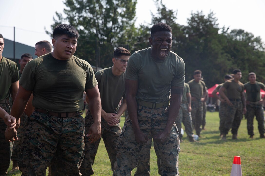 U.S. Marines cheer on  fellow Marines participating in the tire flip challenge during the Security Battalion Field Meet on Sept. 16, 2022. Field meets are held to test Marines on their physical fitness while also bringing the battalion closer together and boosting unit camaraderie. The meet included an ammo can relay race, tire flip challenge, and grappling. Motor Transport Services finished in first place, followed by Marine Corps Base Quantico Food Services and Installation Personnel Administration Center team two. (U.S. Marine Corps photo by Lance Cpl. Jeffery Stevens)