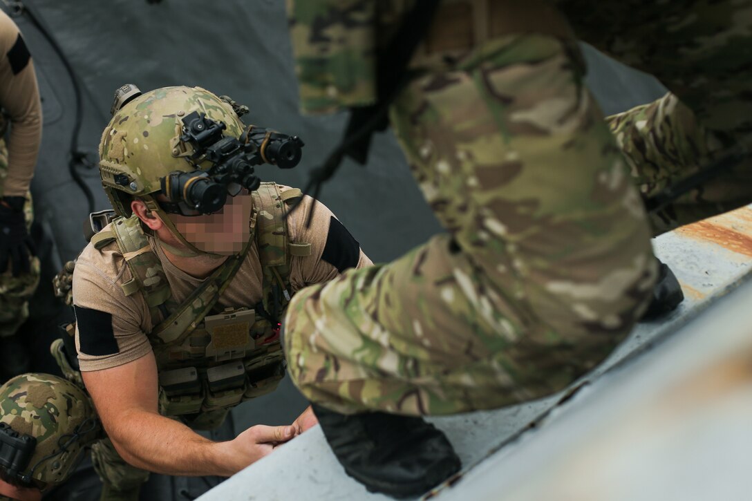 A U.S. Sailor assigned to a Navy SEAL Team, climbs up a ladder during Visit, Board, Search, and Seizure (VBSS) training with partner nations during exercise UNITAS LXIII in Rio de Janeiro, Sept. 15, 2022. UNITAS is the world’s longest-running annual multinational maritime exercise that focuses on enhancing interoperability among multiple nations and joint forces during littoral and amphibious operations in order to build on existing regional partnerships and create new enduring relationships that promote peace, stability, and prosperity in the U.S. Southern Command’s area of responsibility. (U.S. Marine Corps photo by Cpl. Ethan Craw) (This photo has been altered for security purposes by blurring faces and tattoos)