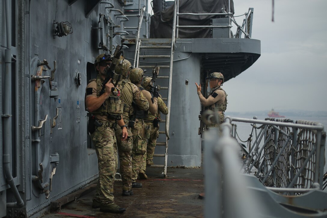 U.S. Sailors assigned to a Navy SEAL Team, make their way toward a command deck during Visit, Board, Search, and Seizure (VBSS) training with partner nations during exercise UNITAS LXIII in Rio de Janeiro, Sept. 12, 2022. UNITAS is the world’s longest-running annual multinational maritime exercise that focuses on enhancing interoperability among multiple nations and joint forces during littoral and amphibious operations in order to build on existing regional partnerships and create new enduring relationships that promote peace, stability, and prosperity in the U.S. Southern Command’s area of responsibility. (U.S. Marine Corps photo by Cpl. Ethan Craw) (This photo has been altered for security purposes by blurring faces and tattoos)