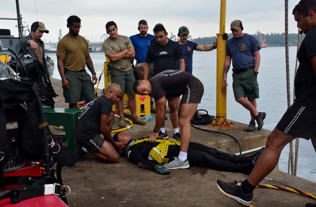 RIO DE JANEIRO – U.S. Navy divers, assigned to Mobile Diving and Salvage Unit 2 (MDSU-2) watch as their Brazilian counterparts conduct a demonstration during UNITAS LXIII, Sept. 14, 2022. UNITAS is the world’s longest-running maritime exercise. Hosted this year by Brazil, it brings together multinational forces from Belize, Brazil, Cameroon, Chile, Colombia, Dominican Republic, Ecuador, France, Guyana, Jamaica, Mexico, Namibia, Panama, Paraguay, Peru, South Korea, Spain, United Kingdom, Uruguay, and the United States conducting operations in and off the coast of Rio de Janeiro. The exercise trains forces to conduct joint maritime operations through the execution of anti-surface, anti-submarine, anti-air, amphibious and electronic warfare operations that enhance warfighting proficiency and increase interoperability among participating naval and marine forces. (U.S. Navy photo by Mass Communication Specialist 3rd Class Jahlena Royer/Released)