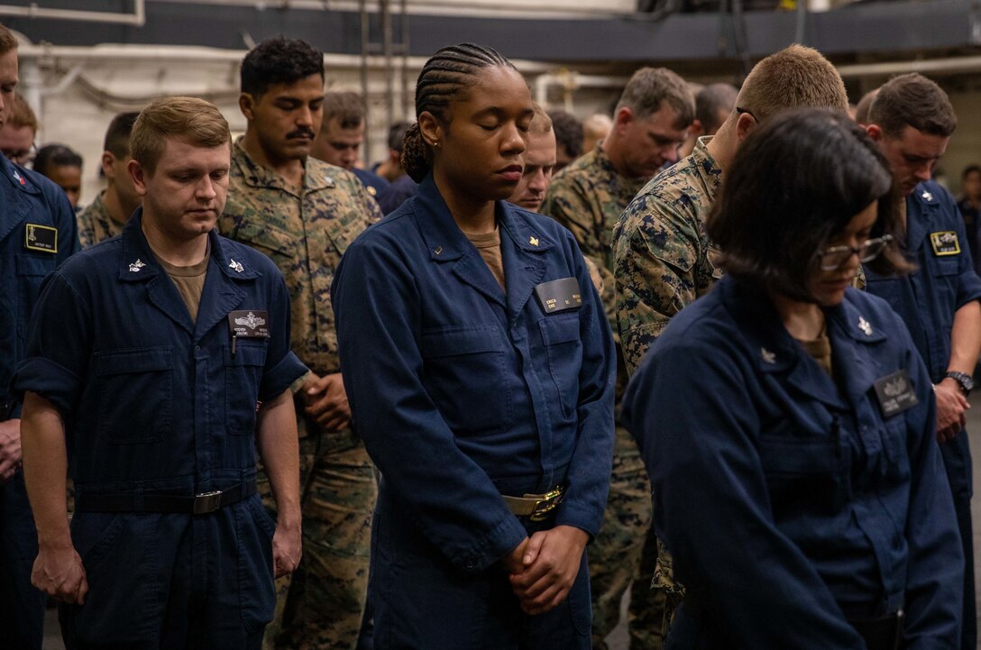 ATLANTIC OCEAN (Sept. 11, 2022) – U.S. Marines and Sailors bow their heads in a moment of silence during a 9/11 memorial ceremony in the hangar bay of the amphibious transport dock ship USS Mesa Verde (LPD 19), Sept. 11, 2022. Mesa Verde is currently underway in the Atlantic Ocean in support of exercise UNITAS LXIII. UNITAS is the world’s longest-running maritime exercise. Hosted this year by Brazil, it brings together multinational forces from Belize, Brazil, Cameroon, Chile, Colombia, Dominican Republic, Ecuador, France, Guyana, Jamaica, Mexico, Namibia, Panama, Paraguay, Peru, South Korea, Spain, United Kingdom, Uruguay, and the United States conducting operations in and off the coast of Rio de Janeiro. The exercise trains forces to conduct joint maritime operations through the execution of anti-surface, anti-submarine, anti-air, amphibious and electronic warfare operations that enhance warfighting proficiency and increase interoperability among participating naval and marine forces. (U.S. Navy photo by Mass Communication Specialist 3rd Class Sydney Milligan)