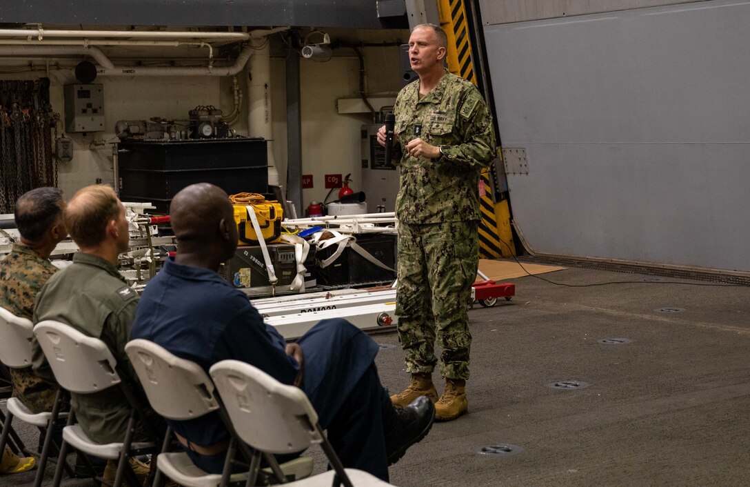 ATLANTIC OCEAN (Sept. 11, 2022) – U.S. Navy Rear Adm. Jim Aiken, commander of U.S. Naval Forces Southern Command/U.S. 4th Fleet speaks during a 9/11 memorial ceremony in the hangar bay of the amphibious transport dock ship USS Mesa Verde (LPD 19), Sept. 11, 2022. Mesa Verde is currently underway in the Atlantic Ocean in support of exercise UNITAS LXIII. UNITAS is the world’s longest-running maritime exercise. Hosted this year by Brazil, it brings together multinational forces from Belize, Brazil, Cameroon, Chile, Colombia, Dominican Republic, Ecuador, France, Guyana, Jamaica, Mexico, Namibia, Panama, Paraguay, Peru, South Korea, Spain, United Kingdom, Uruguay, and the United States conducting operations in and off the coast of Rio de Janeiro. The exercise trains forces to conduct joint maritime operations through the execution of anti-surface, anti-submarine, anti-air, amphibious and electronic warfare operations that enhance warfighting proficiency and increase interoperability among participating naval and marine forces. (U.S. Navy photo by Mass Communication Specialist 3rd Class Sydney Milligan)