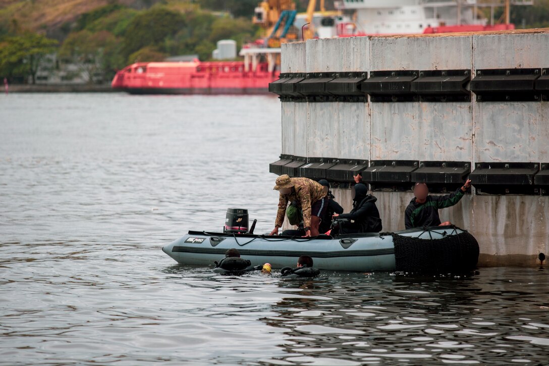 Service members from Brazil with the Grupamento de Mergulhadores de Comabte, Marinha do Brasil (Brazilian Navy Combat Divers Group), Hombres Ranas de Infantería de Marina de Ecuador (Ecuadorian Marine Corps Frogmen), Las Fuerzas de Operaciones Especiales de la Marina de Guerra del Perú (The Special Operations Forces of the Peruvian Navy), and U.S. Navy SEALs assigned to a Naval Special Operations Team, conduct a dive mission as part of exercise UNITAS LXIII in Rio de Janeiro, Sept. 12, 2022. UNITAS is the world's longest-running annual multinational maritime exercise that focuses on enhancing interoperability among multiple nations and joint forces during littoral and amphibious operations in order to build on existing regional partnerships and create new enduring relationships that promote peace, stability, and prosperity in the U.S. Southern Command’s area of responsibility. (U.S. Marine Corps photo by Maj. Thomas Perna) (This photo has been altered for security purposes by blurring faces and tattoos)
