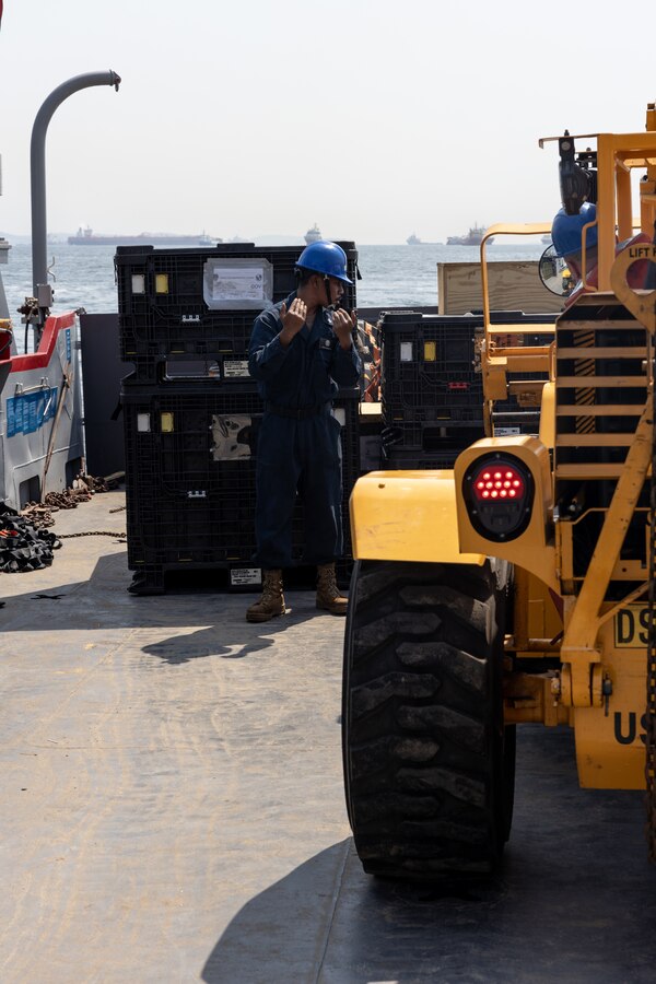 U.S. Navy Boatswains Mate 3rd Class Kinziano Kerai, assigned to Landing Craft, Utility 1663, guides a forklift carrying U.S. Marine Corps equipment loaded from the amphibious transport dock ship USS Mesa Verde (LPD 19) in Rio de Janeiro in support of Special Purpose Marine Air-Ground Task Force UNITAS LXIII, Sept. 3, 2022. Marines and their equipment are moving ashore from the Mesa Verde to begin training during UNITAS LXIII.  UNITAS is the world’s longest-running annual multinational maritime exercise that focuses on enhancing interoperability among multiple nations and joint forces during littoral and amphibious operations in order to build on existing regional partnerships and create new enduring relationships that promote peace, stability and prosperity in the U.S. Southern Command’s area of responsibility. (U.S. Marine Corps photo by Sgt. Brendan Mullin)