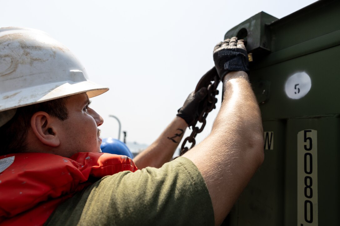U.S. Marine Corps Cpl. Brandon Zinkiewicz, assigned to Combat Cargo aboard the amphibious transport dock ship USS Mesa Verde (LPD 19),  in support of Special Purpose Marine Air-Ground Task Force UNITAS LXIII, secures cargo with chains aboard a landing craft in Rio de Janeiro, Sept. 3, 2022. Marines and their equipment moved ashore from the Mesa Verde to begin training during UNITAS LXIII.  UNITAS is the world’s longest-running annual multinational maritime exercise that focuses on enhancing interoperability among multiple nations and joint forces during littoral and amphibious operations in order to build on existing regional partnerships and create new enduring relationships that promote peace, stability and prosperity in the U.S. Southern Command’s area of responsibility. (U.S. Marine Corps photo by Sgt. Brendan Mullin)