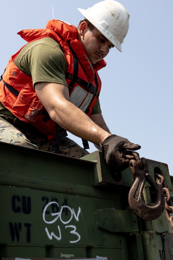U.S. Marine Corps Cpl. Brandon Zinkiewicz, assigned to Combat Cargo aboard the amphibious transport dock ship USS Mesa Verde (LPD 19) in support of Special Purpose Marine Air-Ground Task Force UNITAS LXIII, secures cargo with chains aboard a landing craft in Rio de Janeiro, Sept. 3, 2022. Marines and their equipment are moving ashore from the Mesa Verde to begin training during UNITAS LXIII.  UNITAS is the world’s longest-running annual multinational maritime exercise that focuses on enhancing interoperability among multiple nations and joint forces during littoral and amphibious operations in order to build on existing regional partnerships and create new enduring relationships that promote peace, stability and prosperity in the U.S. Southern Command’s area of responsibility. (U.S. Marine Corps photo by Sgt. Brendan Mullin)