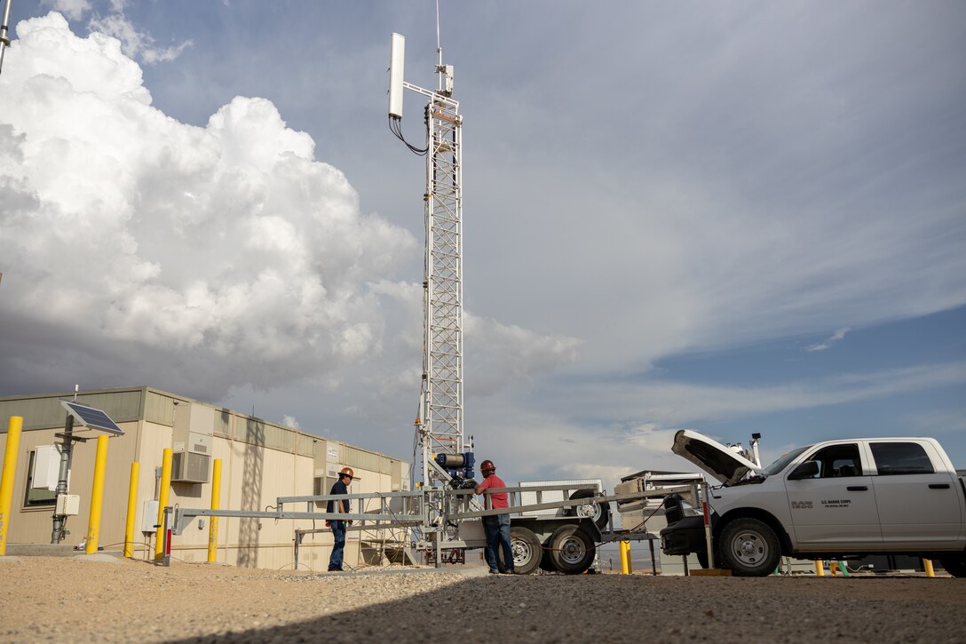 U.S. Marine Corps government employees raise a 5G tower in preparation for a 5G network demonstration at MCAGCC