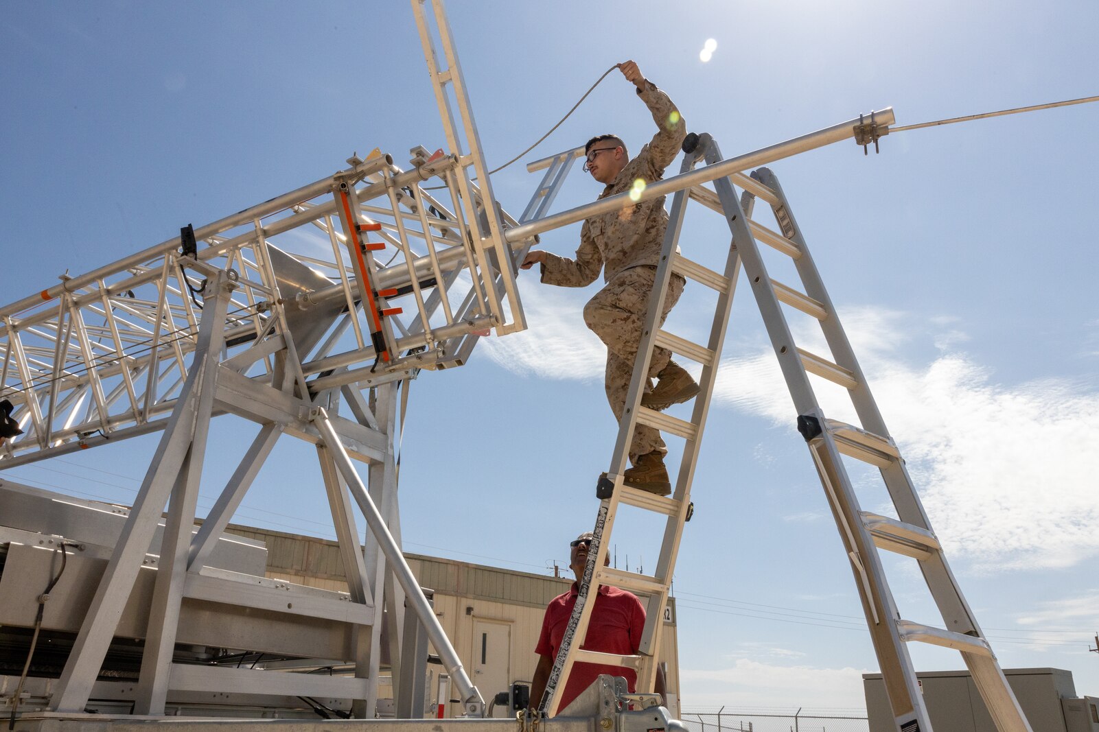 A Marine installs a 5G antenna in preparation for a 5G network demonstration at MCAGCC