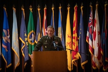 man wearing u.s. army uniform standing on a stage.