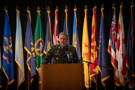 man wearing u.s. army uniform standing on a stage.