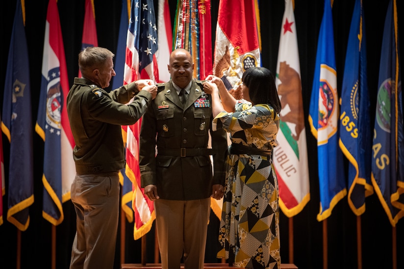 man wearing u.s. army uniform standing on a stage.