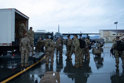 Soldiers of the Alaska Army National Guard transfer their luggage prior to boarding a HC-130 Combat King II for transport to Bethel, Alaska, Sept. 21, 2022. Approximately 100 members of the Alaska Organized Militia, which is comprised of the Alaska National Guard, Alaska State Defense Force and Alaska Naval Militia, were activated following a disaster declaration issued Sept. 17 after the remnants of Typhoon Merbok caused dramatic flooding across more than 1,000 miles of Alaskan coastline. (Alaska National Guard photo by Victoria Granado)