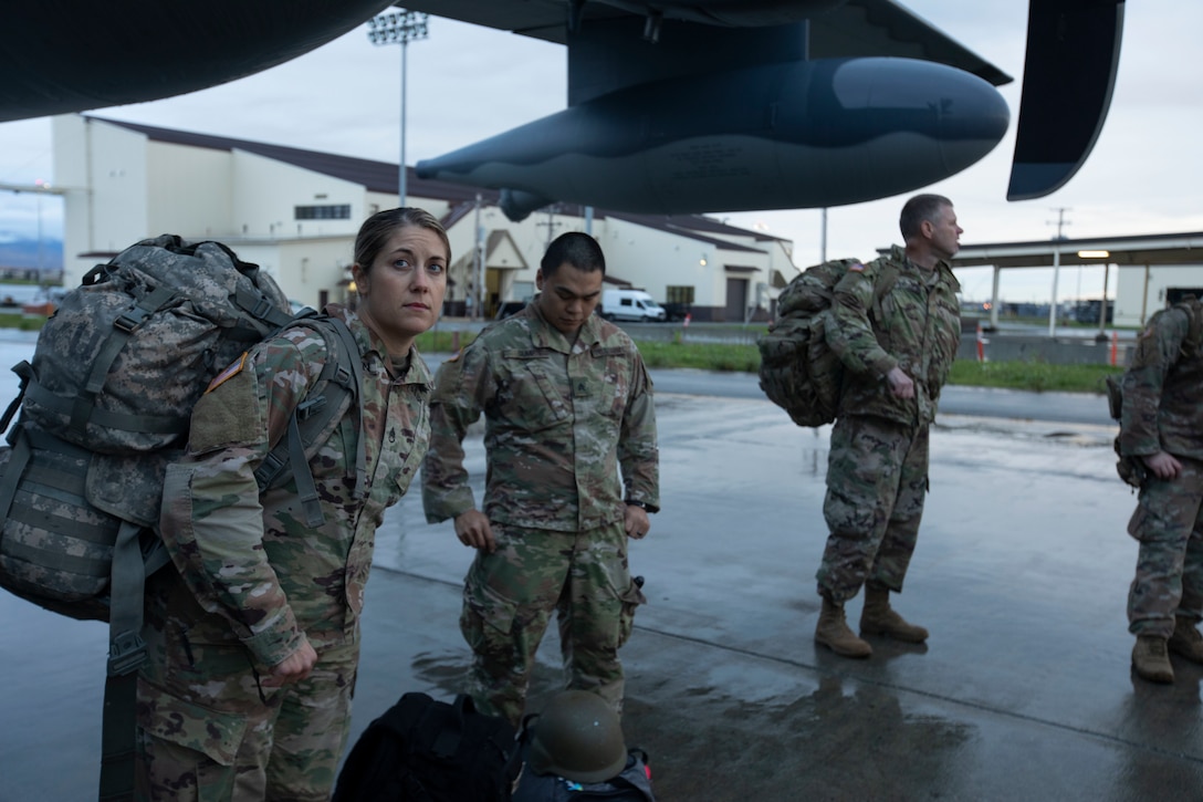 Soldiers of the Alaska Army National Guard transfer their luggage prior to boarding a HC-130 Combat King II for transport to Bethel, Alaska, Sept. 21, 2022. Approximately 100 members of the Alaska Organized Militia, which is comprised of the Alaska National Guard, Alaska State Defense Force and Alaska Naval Militia, were activated following a disaster declaration issued Sept. 17 after the remnants of Typhoon Merbok caused dramatic flooding across more than 1,000 miles of Alaskan coastline. (Alaska National Guard photo by Victoria Granado)