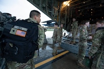 Soldiers of the Alaska Army National Guard transfer their luggage prior to boarding a HC-130 Combat King II for transport to Bethel, Alaska, Sept. 21, 2022. Approximately 100 members of the Alaska Organized Militia, which is comprised of the Alaska National Guard, Alaska State Defense Force and Alaska Naval Militia, were activated following a disaster declaration issued Sept. 17 after the remnants of Typhoon Merbok caused dramatic flooding across more than 1,000 miles of Alaskan coastline. (Alaska National Guard photo by Victoria Granado)