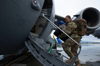 An Alaska Army National Guardsman boards a C-17 Globemaster III for transport to Eielson Air Force Base to pick up additional service members, Sept. 21, 2022. Approximately 100 members of the Alaska Organized Militia, which is comprised of the Alaska National Guard, Alaska State Defense Force and Alaska Naval Militia, were activated following a disaster declaration issued Sept. 17 after the remnants of Typhoon Merbok caused dramatic flooding across more than 1,000 miles of Alaskan coastline. (Alaska National Guard photo by Victoria Granado)