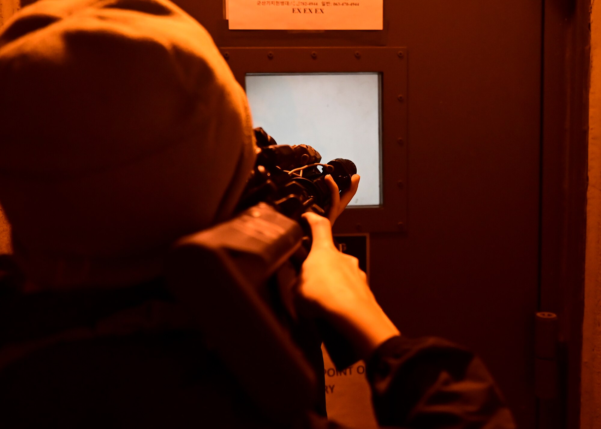 A U.S. Air Force Airman assigned to the 8th Security Forces Squadron (SFS), acting as an adversary force, attempts to breach a doorway during a training event at Kunsan Air Base, Republic of Korea, Sept. 15, 2022. 8th SFS airmen were tasked with responding and neutralizing the simulated adversary forces as they attempted to breach portions of the installation. (U.S. Air Force photo by Staff Sgt. Isaiah J. Soliz)