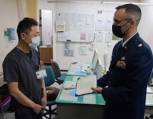 A military member presents an appreciation letter to a doctor