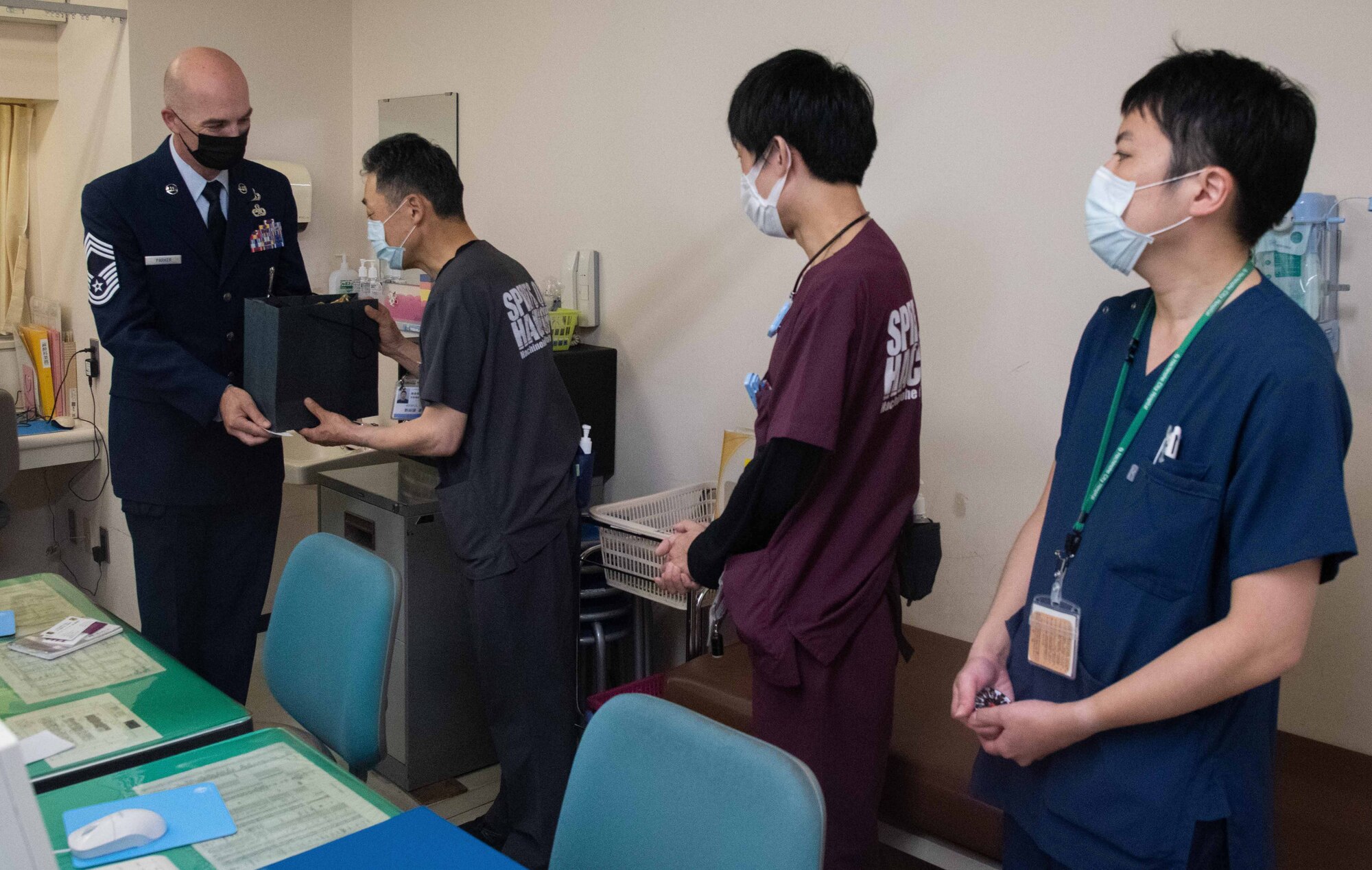 A military member hands a gift to Hachinohe doctors