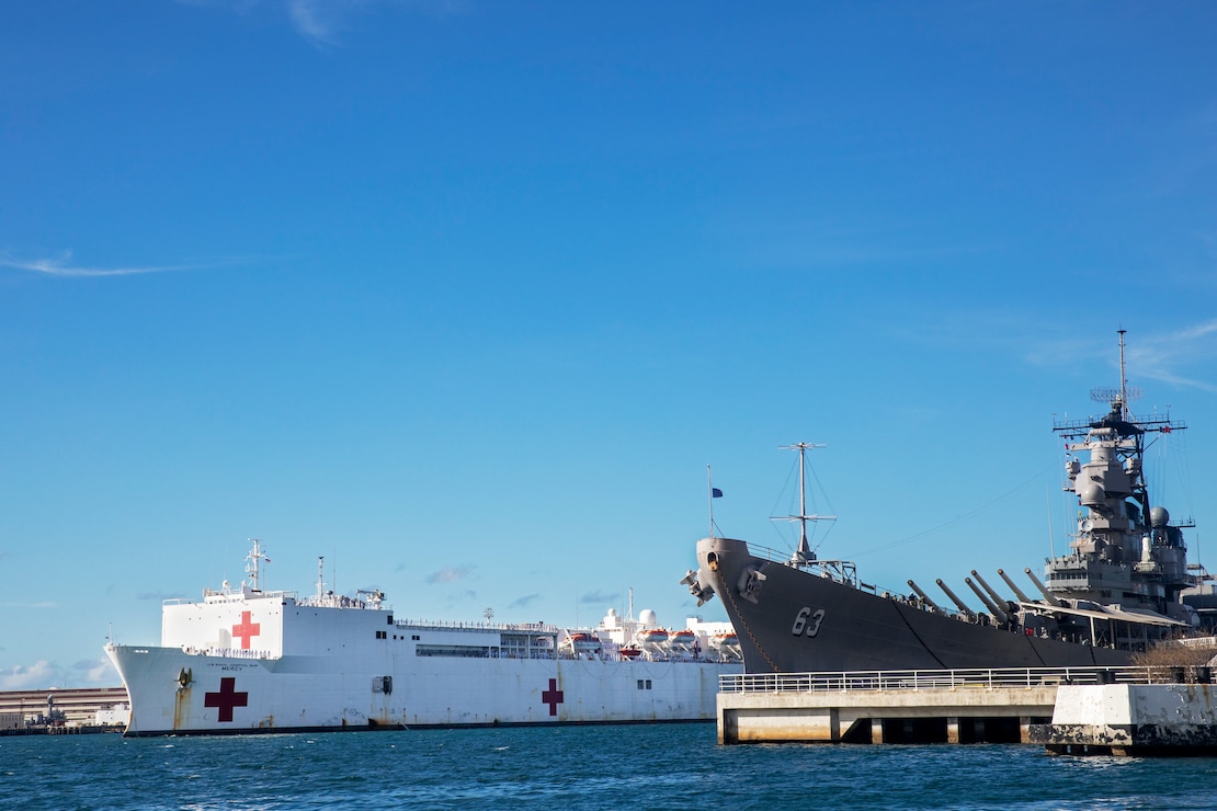 The Military Sealift Command hospital ship USNS Mercy (T-AH 19) passes the battleship USS Missouri Memorial while arriving at Joint Base Pearl Harbor-Hickam during Pacific Partnership 2022.