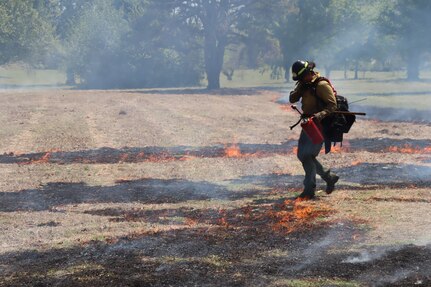 firefighter starts prescribed burn