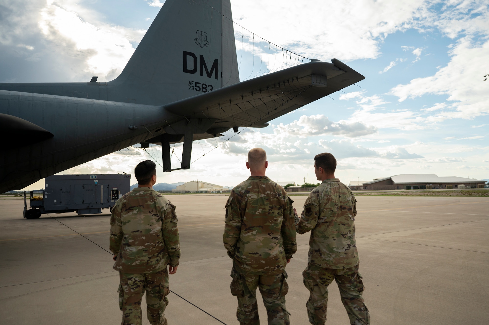 Photo of maintainers in front of an EC-130H aircraft.