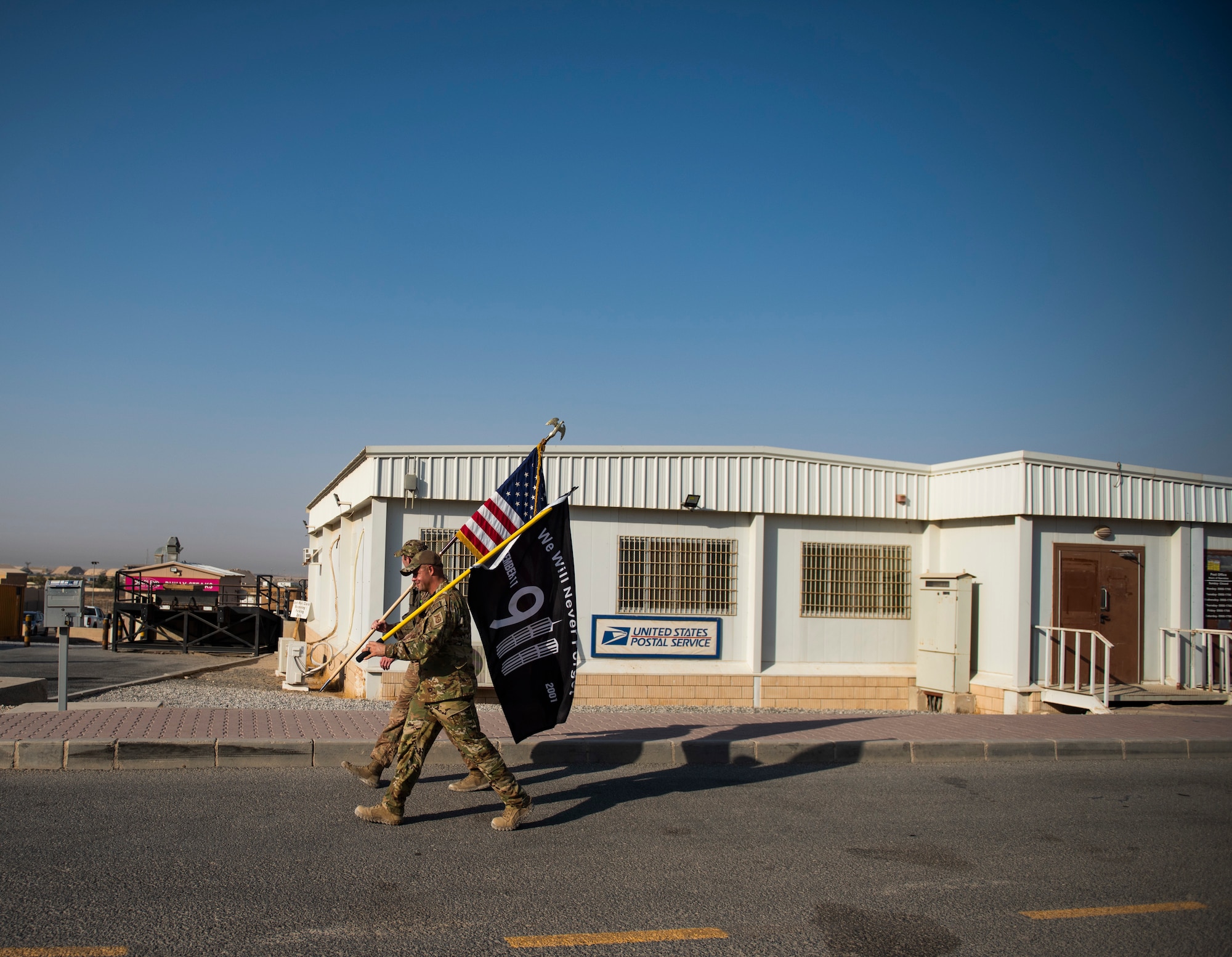 Staff Sgt. Aaron Watts, 386 Expeditionary Civil Engineer Squadron firefighter, marches along the side of a member of the 386 Expeditionary Security Forces Squadron at Ali Al Salem Air Base, Kuwaiti, 12 Sept. 2022 in remembrance of those lost on Sept. 11, 2001. Members from multiple branches of service and coalition teammates from throughout the world took part in the 24-hour march. (U.S. Air Force photo by Senior Master Sgt. David Salanitri)