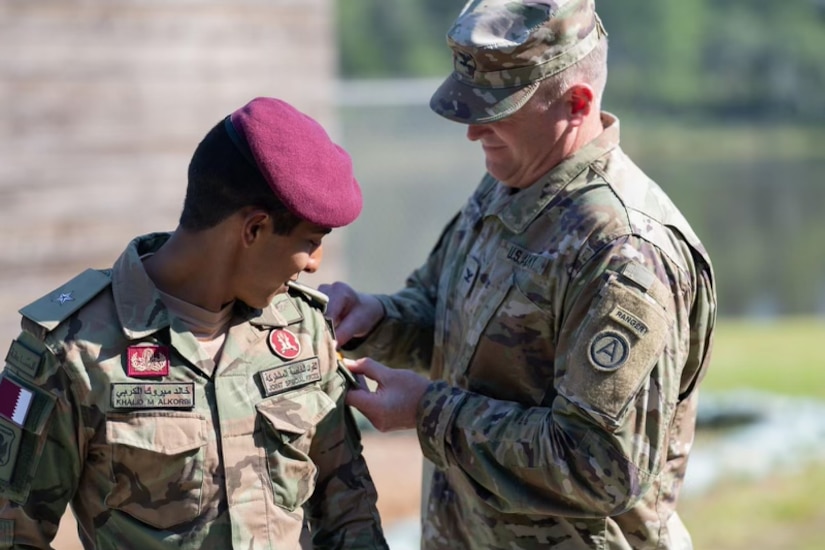 Col. Chuck Canon, Chief of Security Cooperation, USARCENT., places the Ranger tab onto 2nd Lt. Khalid M. Alkorbi's uniform. Alkorbi, a member of the Qatari Joint Special Forces, graduated from U.S. Army Ranger School at Fort Benning, Georgia, September 16, 2022. He is the second soldier from Qatar to complete the elite course and earn the Ranger tab.