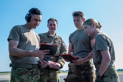 U.S. Air Force Airmen from the 15th and 16th Airlift Squadrons look over a checklist of items to be completed during a joint training exercise with the North Charleston Police Department at Joint Base Charleston, South Carolina, Sept.16, 2022. The exercise prepared loadmasters for a wartime scenario of loading vehicles of a larger size onto a C-17 Globemaster III aircraft.  (U.S. Air Force photo by Airman 1st Class Christian Silvera)